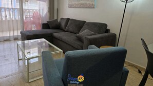 A modern living room with a grey sectional sofa, a glass coffee table, and a floor lamp. - Welcoming seafront apartment Tv15 (Torrevieja)