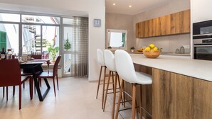 Een moderne keuken met een houten aanrecht, barstoelen en een schaal met citroenen.