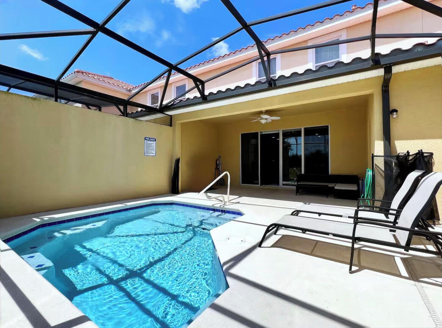 A swimming pool with a glass ceiling, a bench, and a sign indicating a pool area.