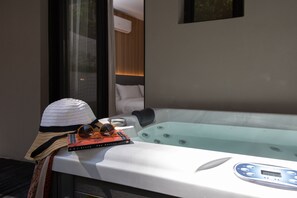 A modern bathroom with a bathtub, a towel, sunglasses, and a book. - LUX&EASY Athens Downtown Residences (Athens)