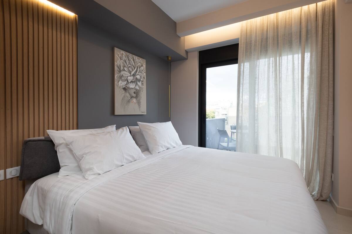 Habitación de hotel con una cama grande, un cuadro en la pared y vistas por la ventana.