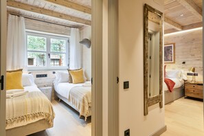 Un dormitorio con dos camas, un espejo grande y una ventana con cortinas.