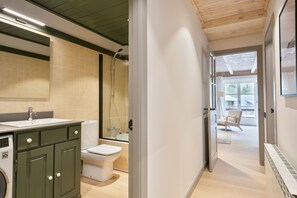 Un baño moderno con ducha, inodoro y lavamanos.