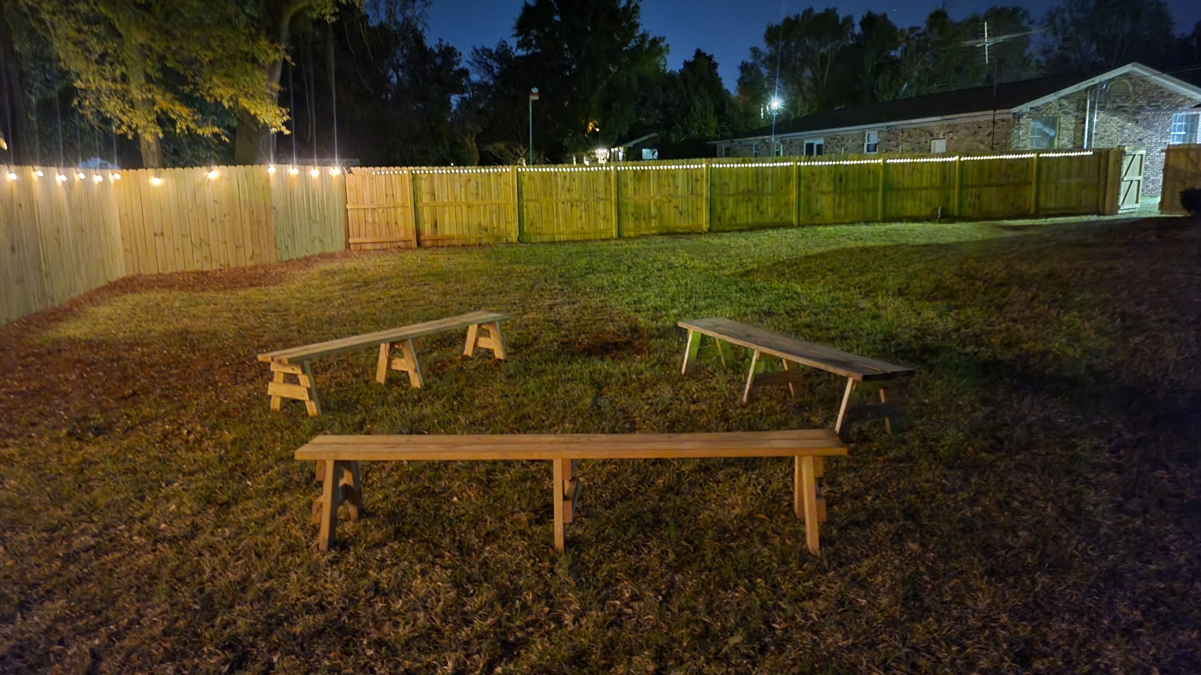 Eine grüne Außenanlage mit Holzbänken und einem Holzzaun.