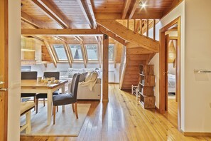 Een ruime loft met hoge plafonds, houten balken en dakramen.
