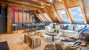 A cozy attic room with a dining area, a sofa, and a coffee table. - Luderna - Tríplex Val de Ruda E3 der Humarau (Baqueira)