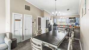 A spacious kitchen with a dining area, white cabinetry, and a chandelier. - Fantastic Ocean Views, Community Pool, Dogs Welcome, Open Deck, KHSDA5 (Kitty Hawk)
