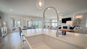 Una cocina moderna con una isla central, un ventanal grande y una zona de comedor con vistas.