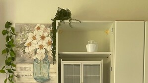 A kitchen with white cabinets, a black countertop, a Zoppa dishwasher, and a window with frosted glass doors. - Giorgio's Dream (Chiavari)