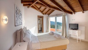 Une chambre avec un lit, une télévision, un bureau et une fenêtre donnant sur un beau paysage.