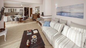 Un salon spacieux comprenant un canapé, une table basse et un coin repas avec des chaises et une table.