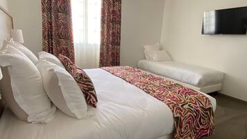 Een hotelkamer met een groot bed, een bank, een televisie en een kamer met een patroon.