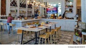 Zona de bar moderna con estantería para vinos, barra y asientos.