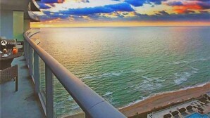 Un balcón con vista al océano y al atardecer.