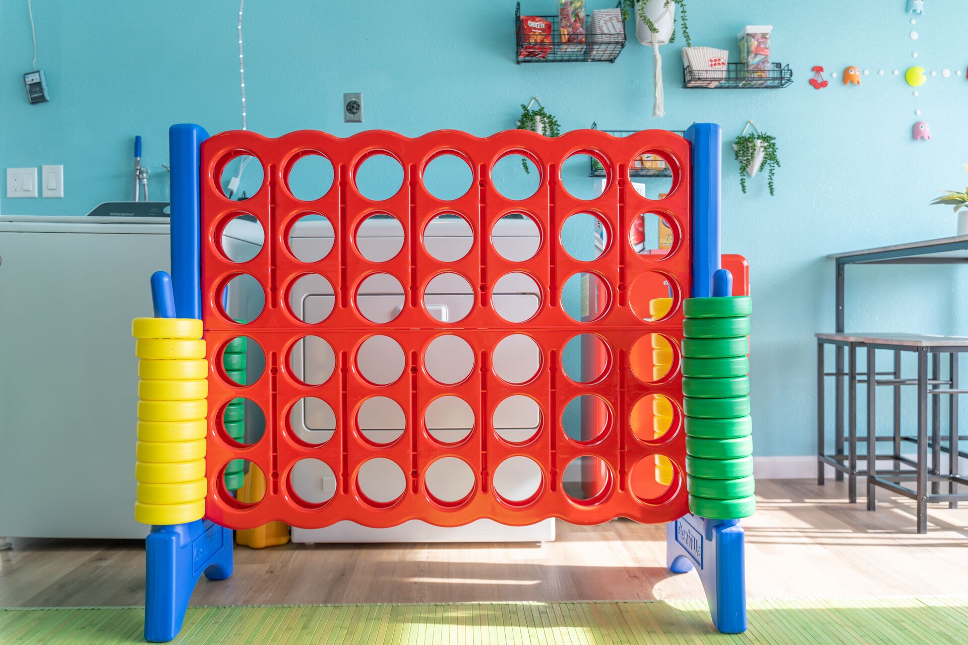 Una habitación con pared azul, suelo de madera y una estructura de juego roja y azul.