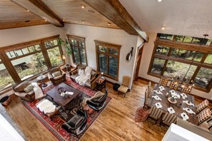 Un'ampia zona giorno con un grande tavolo da pranzo in legno apparecchiato per sei persone, circondato da sedie a scacchi.