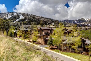 Un quartiere residenziale con case, una strada e montagne sullo sfondo.