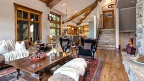 Un salon spacieux avec une table à manger en bois, des sièges confortables et une cheminée en pierre.