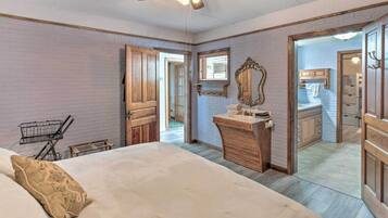 A bedroom with a bed, a wooden dresser, a mirror, and a ceiling fan.