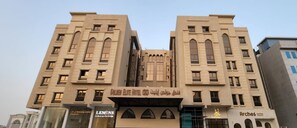 A hotel with a modern facade, featuring arched windows and a central entrance. - Golden Elite Hotel (Al Khobar)