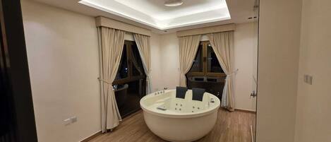 A modern bathroom with a skylight, a bathtub, and a shower area.
