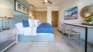 Un dormitorio con cama, mesitas de noche, escritorio y una silla.