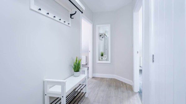 Une salle de bain moderne avec un meuble-lavabo blanc, un miroir et une plante en pot.
