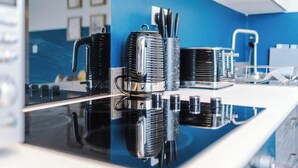 A kitchen with a black countertop, chrome appliances, and a blue wall. - Hidden Gem within Central Chester - Great Location (Chester)