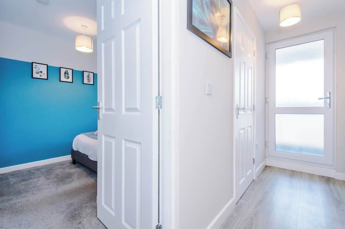 A room with a bed, a door, and a window.