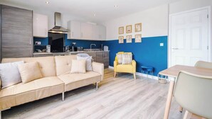 A modern kitchen with white cabinets, a built-in oven, and a stainless steel range hood. - Hidden Gem within Central Chester - Great Location (Chester)
