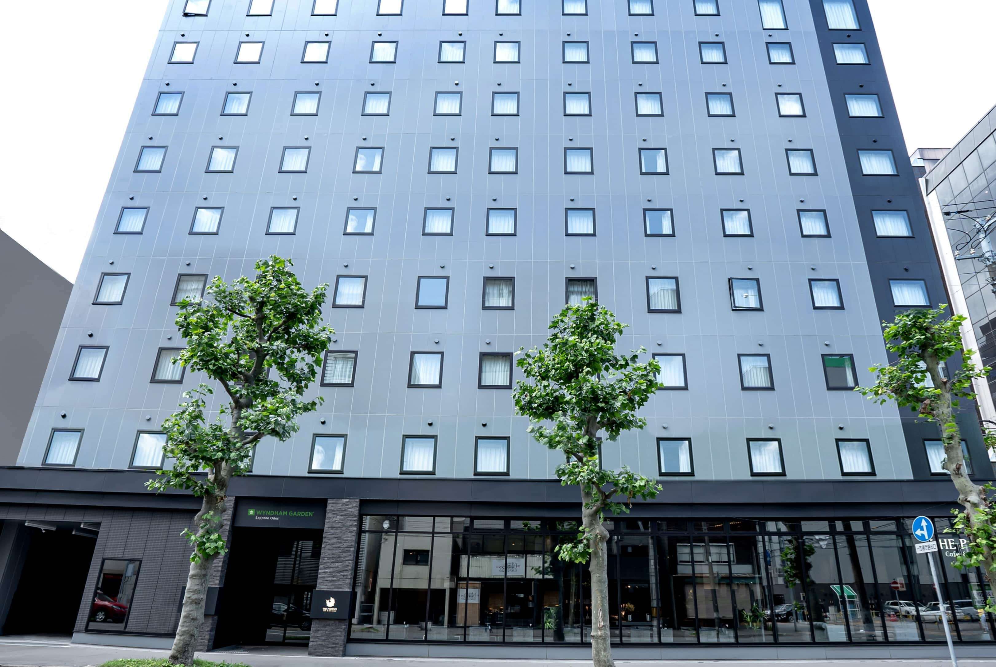 Ein mehrstöckiges Hotel mit moderner Fassade, großen Fenstern und einem Eingangsbereich im Erdgeschoss mit einem sichtbaren Restaurant.