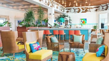 A spacious lobby with high ceilings, modern lighting, and a bar area.