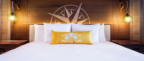 Cama bem arrumada com lençóis brancos e uma única almofada decorativa com texto.