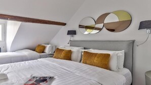 A hotel room with two beds, a large mirror, a lamp, and a window. - A paradise for food lovers- An essence of French gastronomy in Montrogueil (Paris)