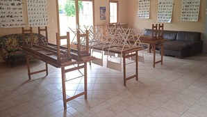 Una habitación con mesas y sillas de madera, un sofá y paredes decoradas con caligrafía.