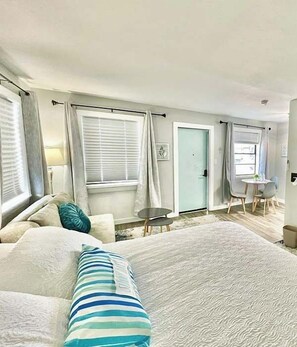 Ein Schlafzimmer mit einem großen Bett, einem kleinen Tisch und einem Stuhl.