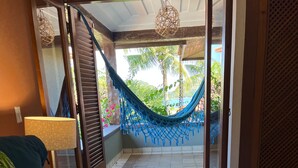 Une chambre d’hôtel avec un lit, un hamac et une vue sur l’extérieur.