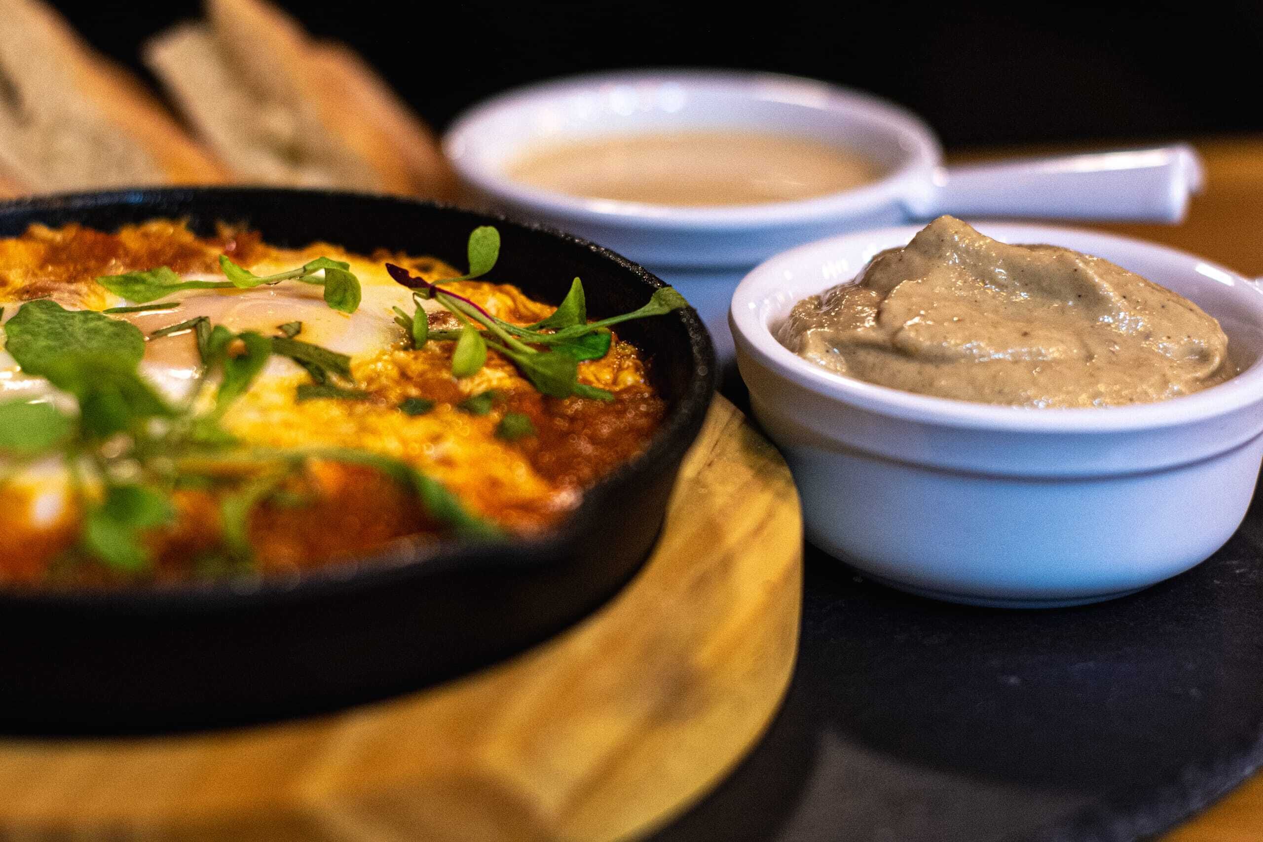 Un plato de comida con un recipiente de salsa y una cuchara.