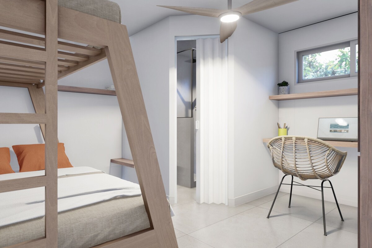 A modern room with a bunk bed, a desk, a chair, and a ceiling fan.