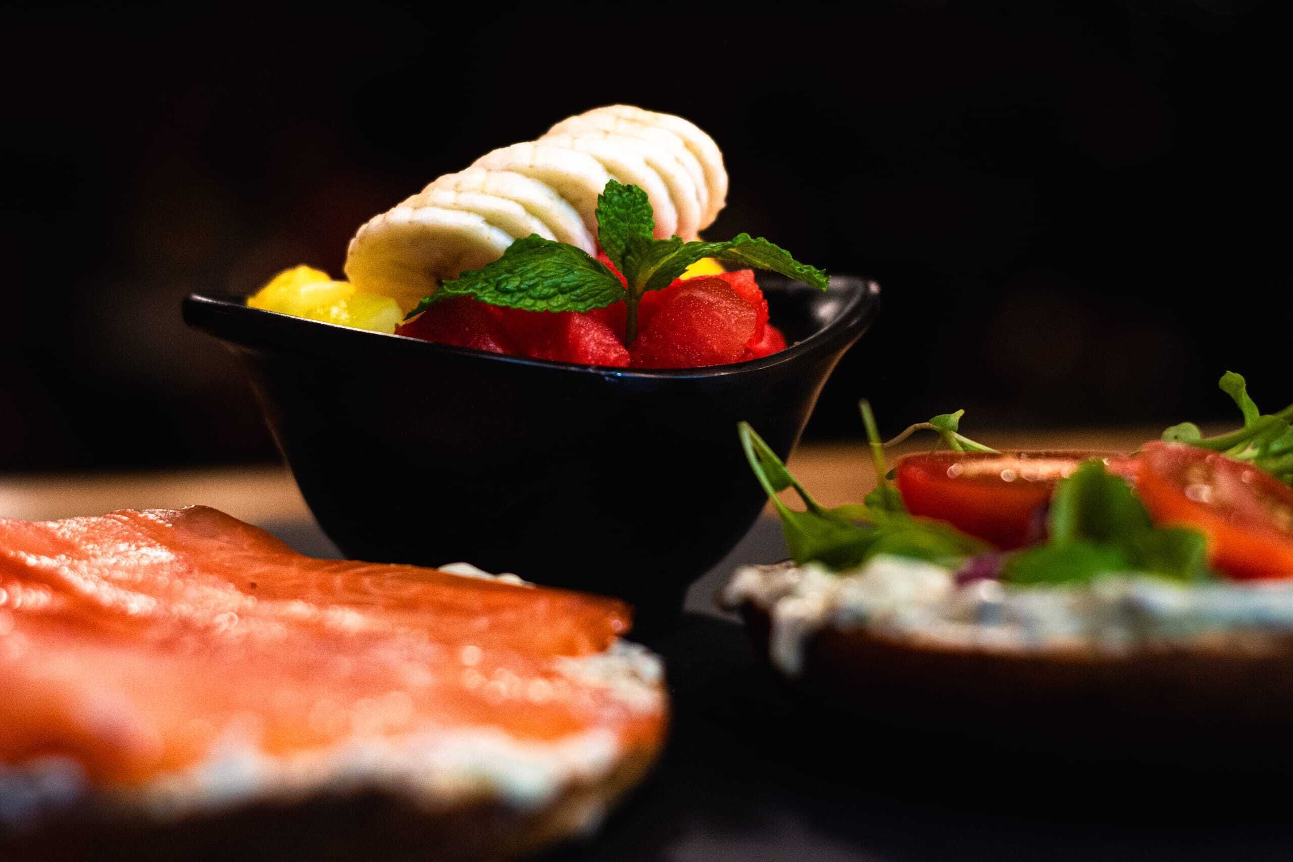 Un dessert composé de crème glacée et de fraises, servi dans un bol noir.