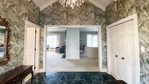 A spacious hallway with a marble floor, a chandelier, and a view into a living area with a sofa and a coffee table. - Exquisite, first floor stone ranch Gettysburg large kitchen/living area - quiet  (Gettysburg)