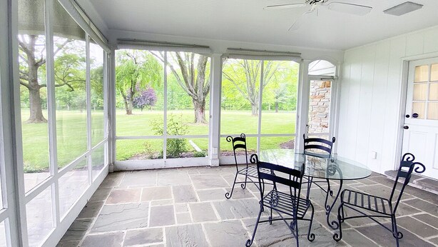 A covered patio with a glass table and metal chairs, stone flooring, and a view of a grassy garden. - Exquisite, first floor stone ranch Gettysburg large kitchen/living area - quiet  (Gettysburg)