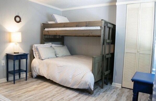 A bunk bed room with a striped bedspread, a bedside table with a lamp, and a wardrobe with louvered doors. - Cozy in the Cove: Smith Lake Cullman County:  Private Dock! Year Round Water (Cullman)