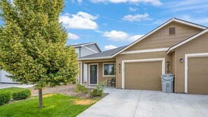 A residential house with a garage, a driveway, and a lawn. - Townhouse near College of Idaho, workspace (Caldwell)