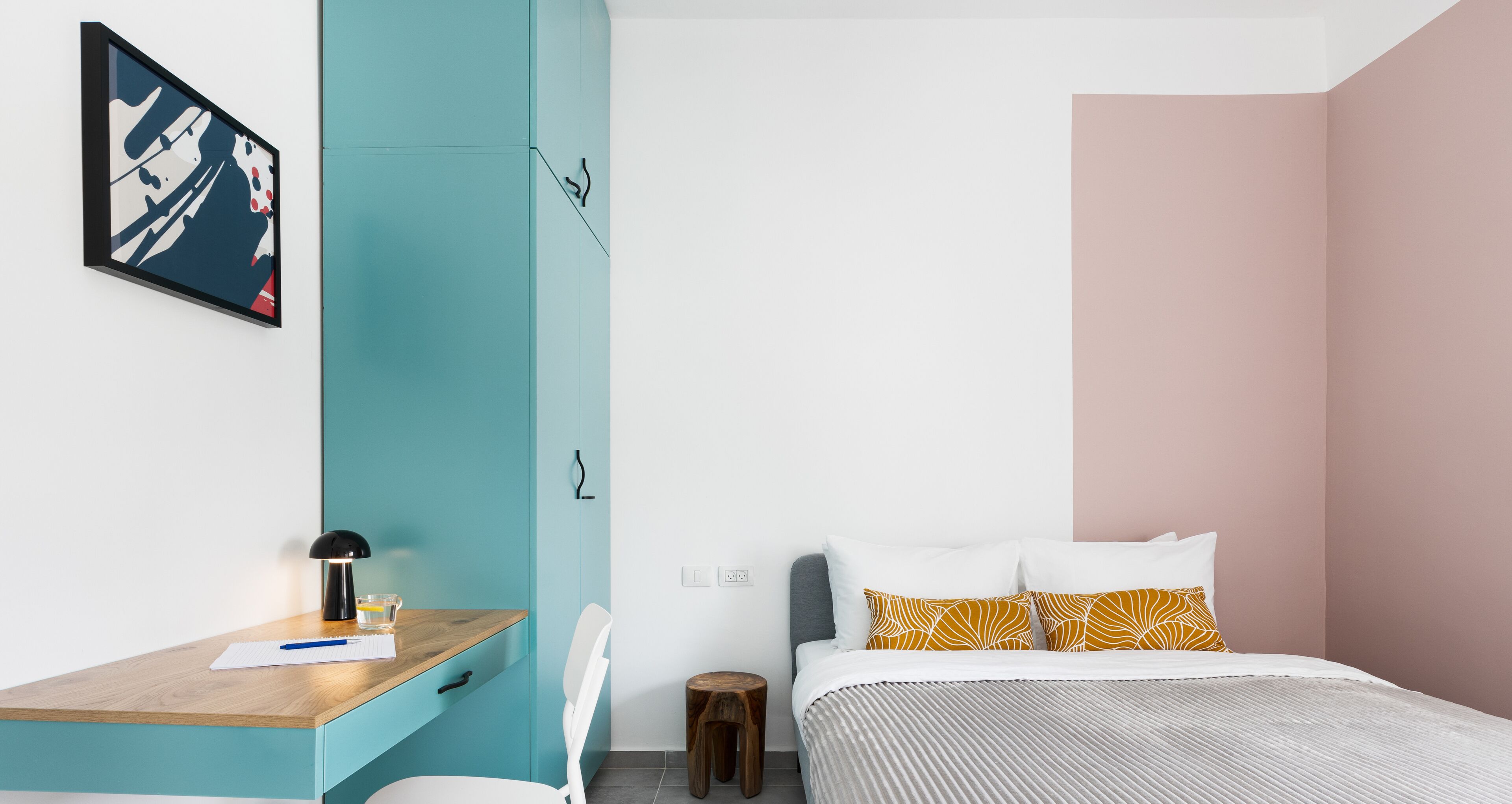 A modern bedroom with a bed, a desk, and a chair.
