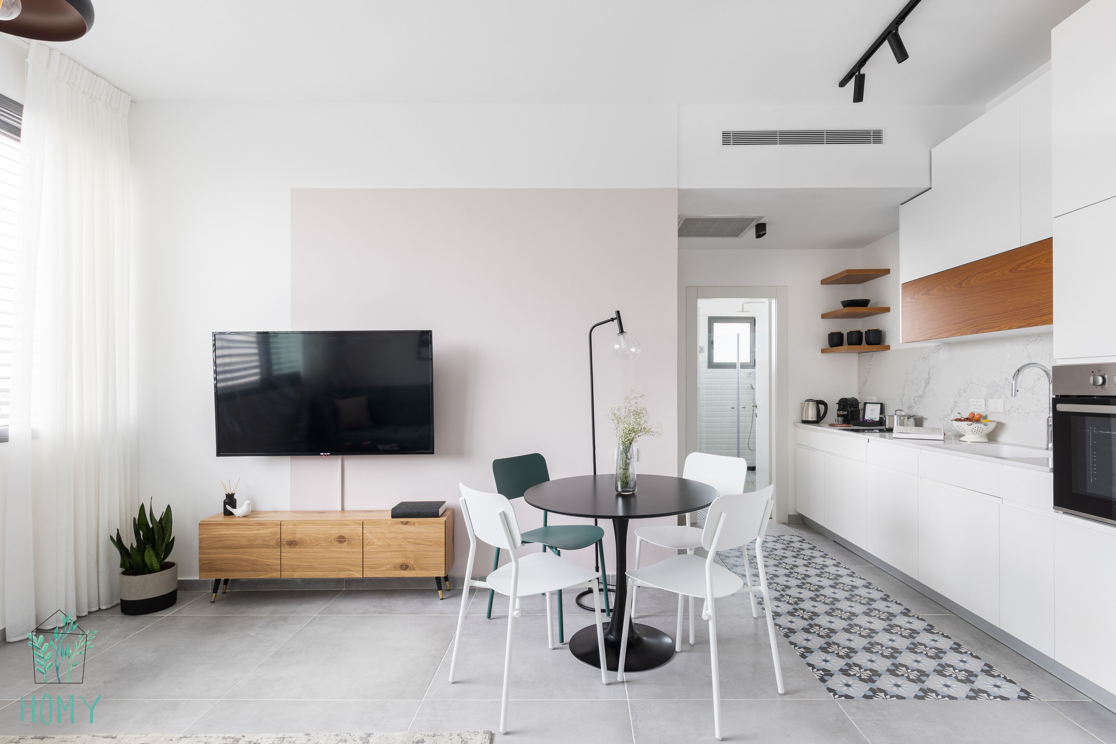 A modern kitchen with white cabinets, a black countertop, and a built-in oven.