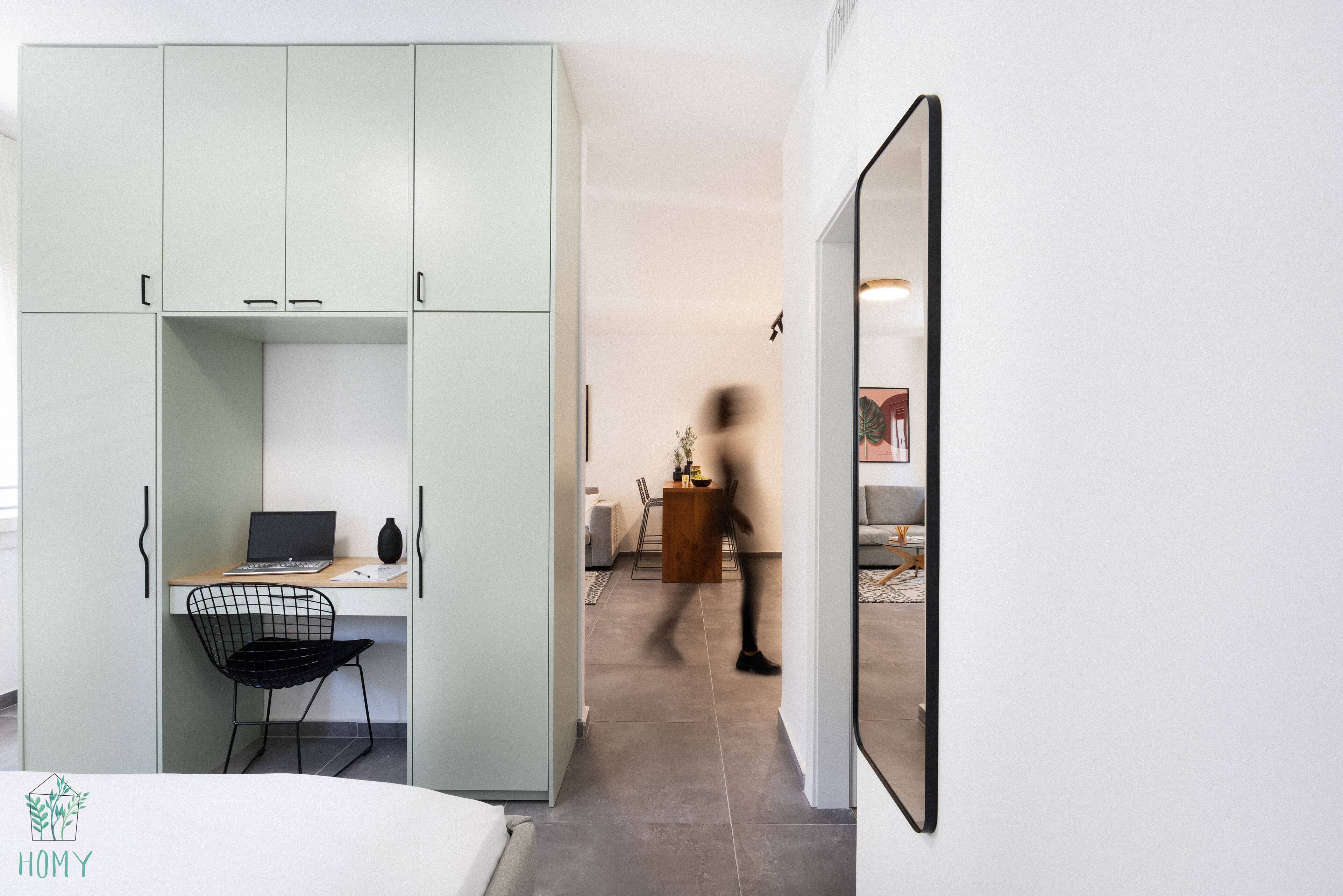 Una habitación moderna con escritorio, silla y armario.