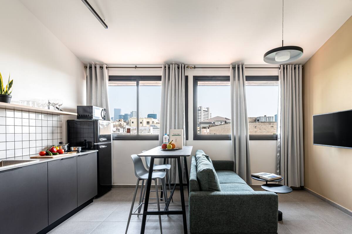 Une cuisine moderne avec un coin repas, un canapé et un téléviseur.