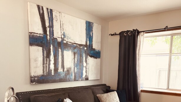A modern living room with a sectional sofa, a coffee table, and a ceiling fan.