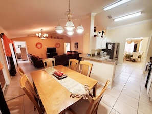 Enjoy meals together at the dining table for four, surrounded by a comfortable seating area and modern kitchen.